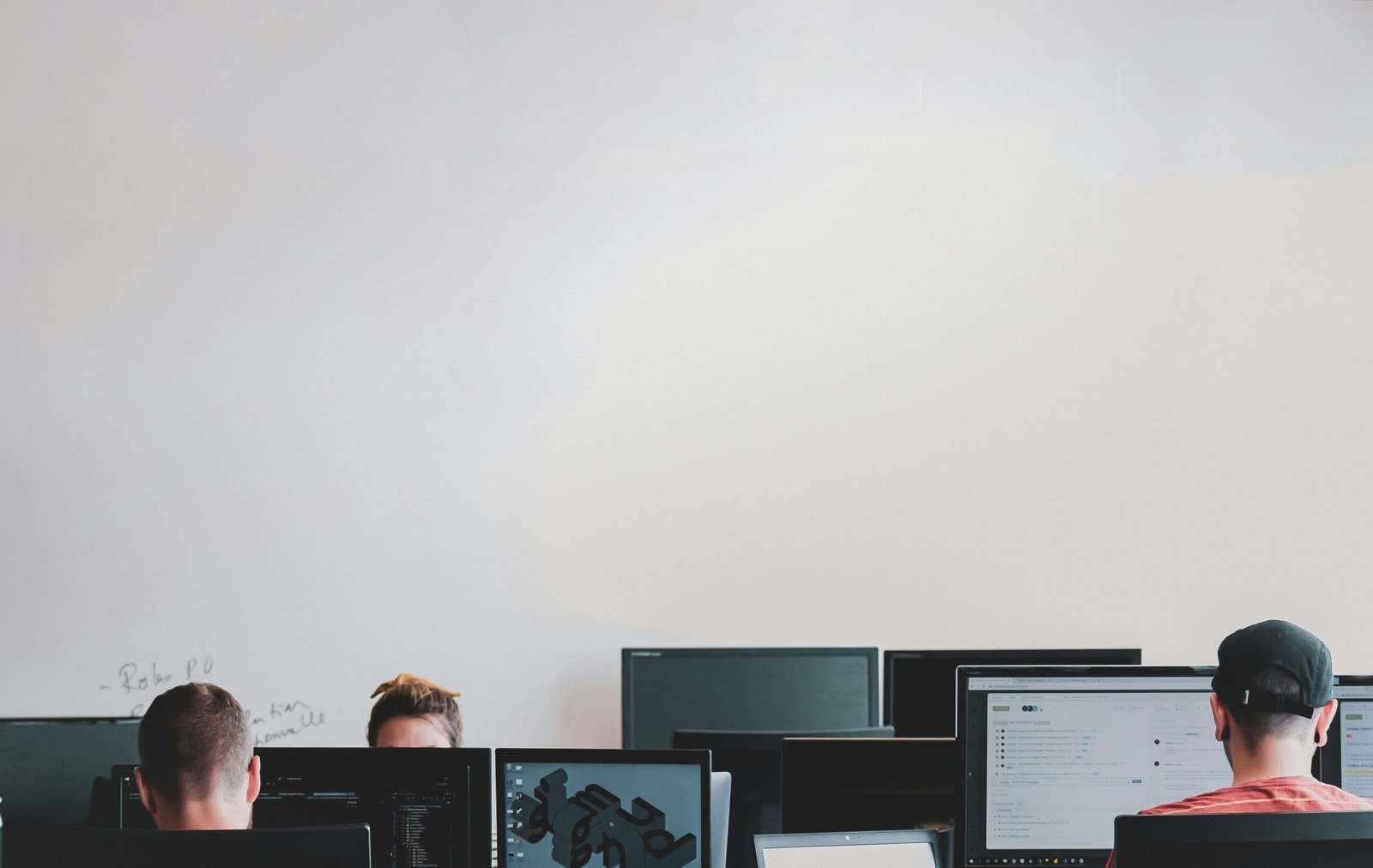 man in black jacket sitting beside black flat screen computer monitor